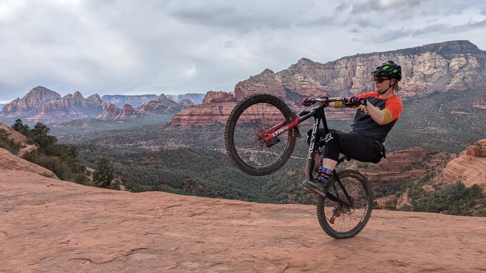 Biker doing a wheelie with red rock background